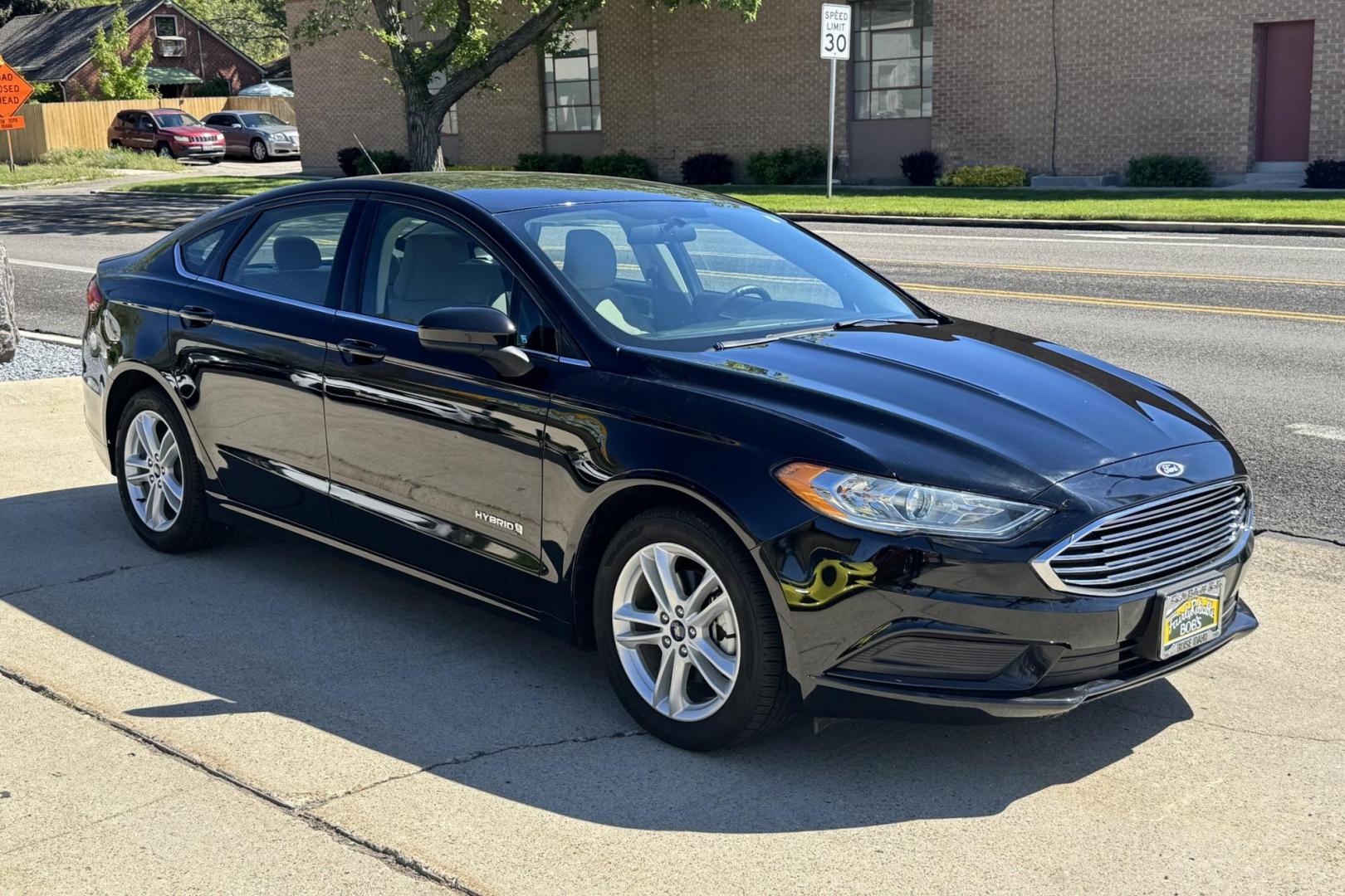 2018 Black /Tan Ford Fusion (3FA6P0UU8JR) with an 4 Cyl 2.0 Liter Hybrid engine, Automatic transmission, located at 2304 W. Main St., Boise, ID, 83702, (208) 342-7777, 43.622105, -116.218658 - Great Fuel Economy! Great Value! - Photo#1